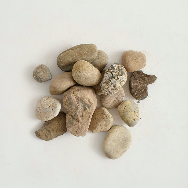 Collection of small, natural stones on a light gray background