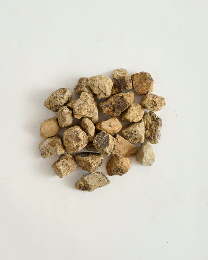 Pile of small rocks on a light gray background