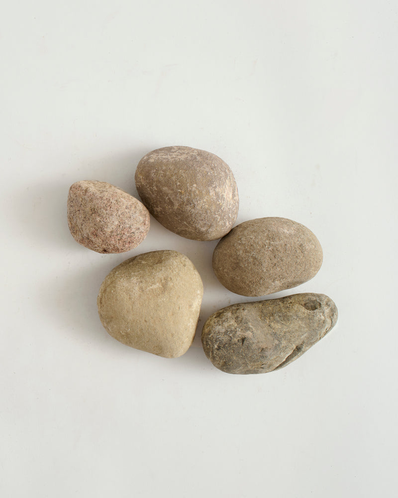 Five beige stones on a light gray background