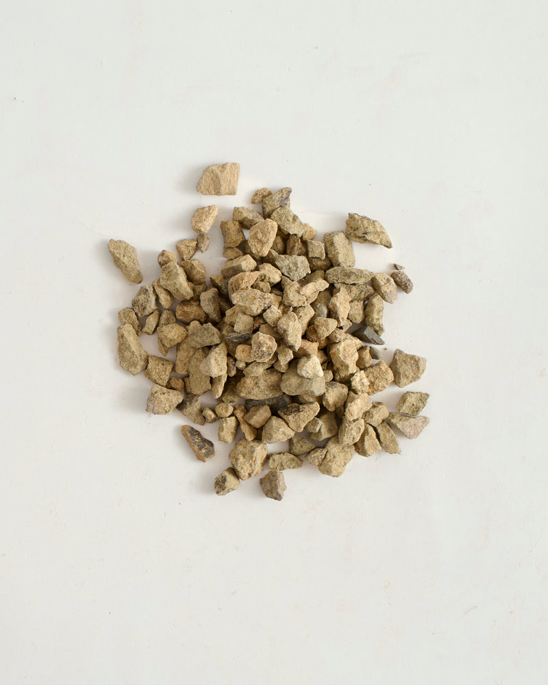 Pile of small, light brown rocks on a white background