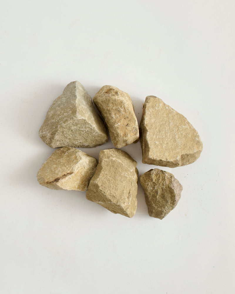 Five irregularly shaped stones on a light gray background