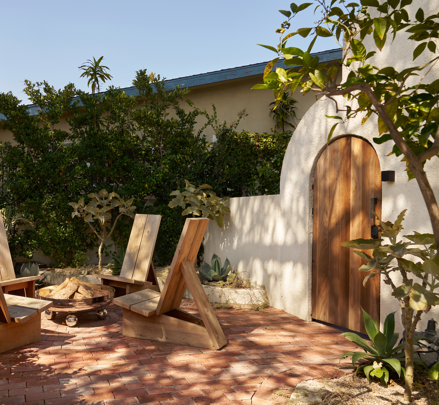 Plank wooden chairs by fire pit over bricks