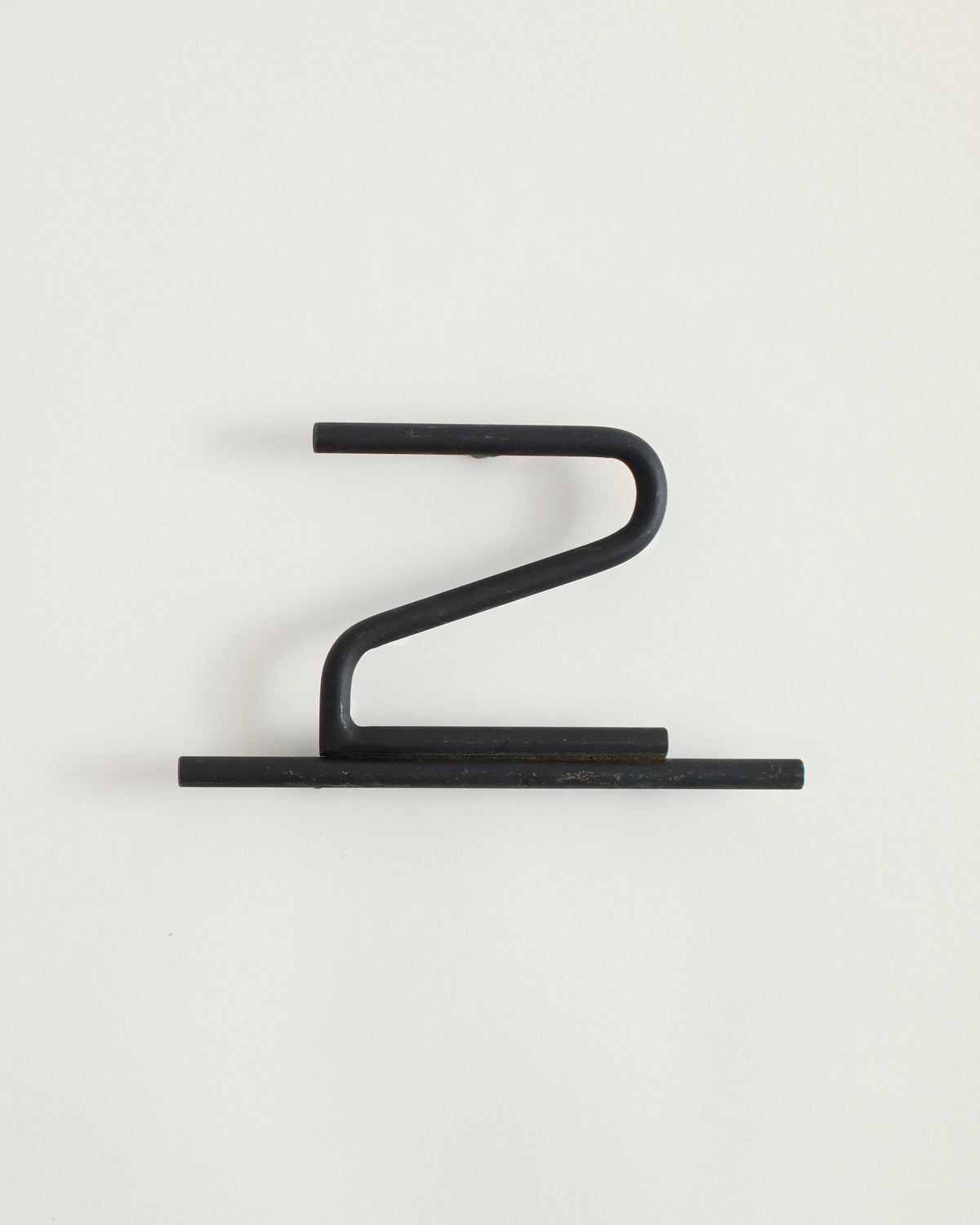 Black house number '2' on a white wall 