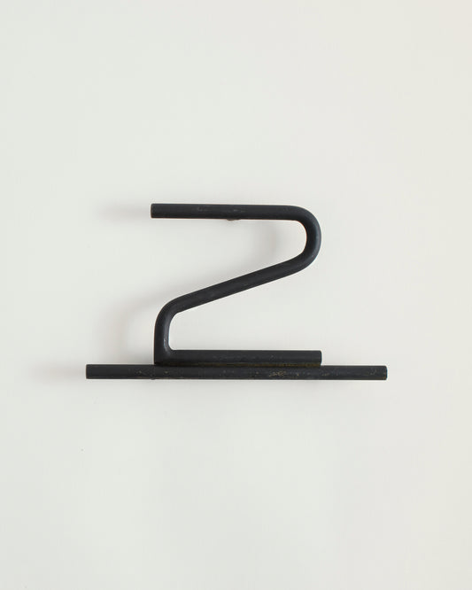 Black house number '2' on a white wall 