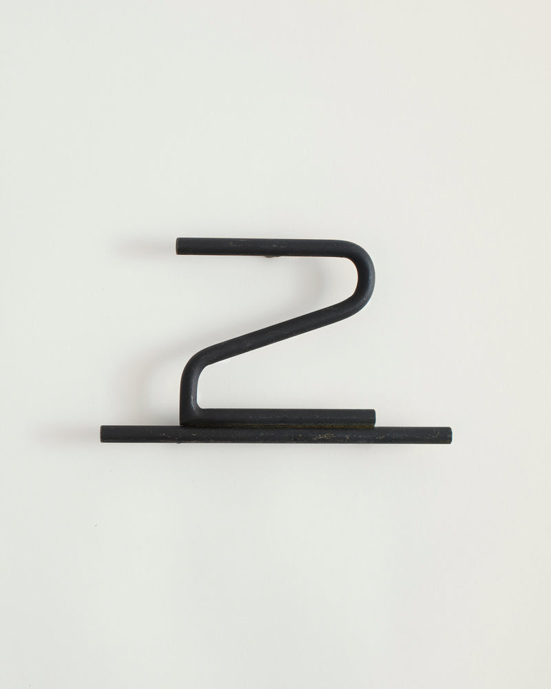 Black house number '2' on a white wall 