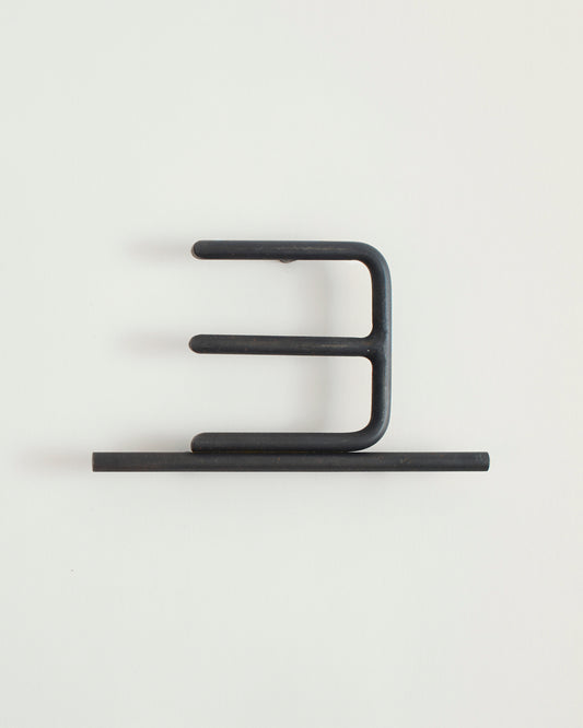Black house number '3' on a white wall 