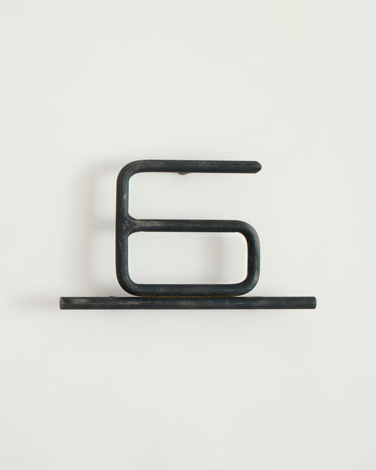 Black house number '6' on a white wall 