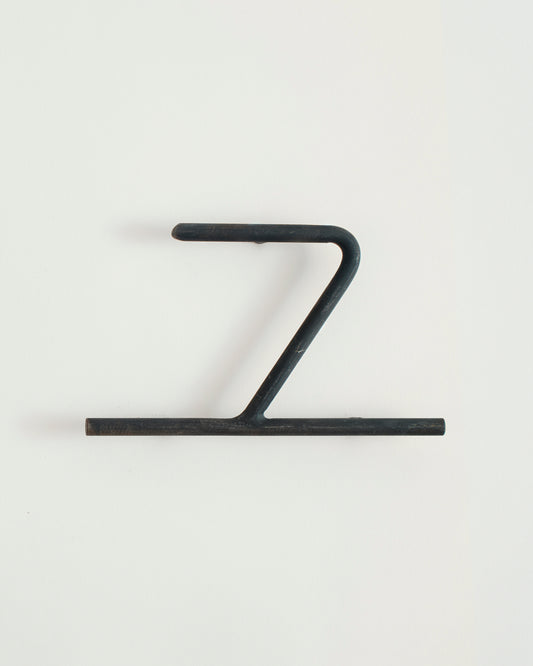 Black house number '7' on a white wall 