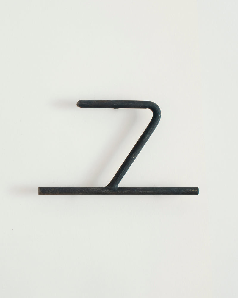 Black house number '7' on a white wall 
