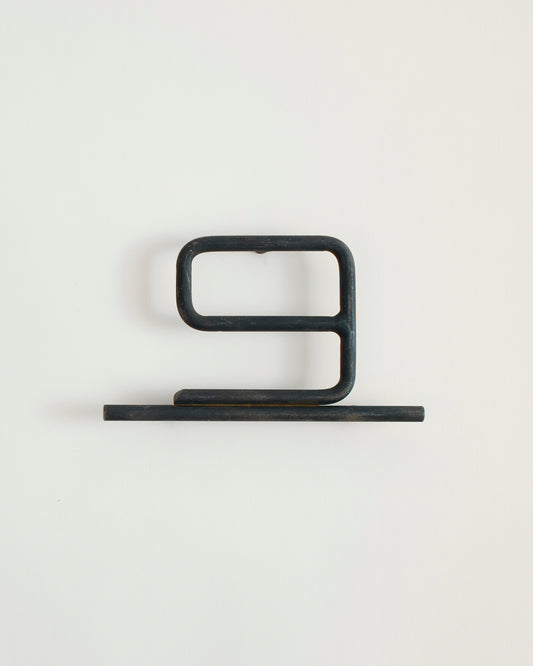 Black house number '9' on a white wall 