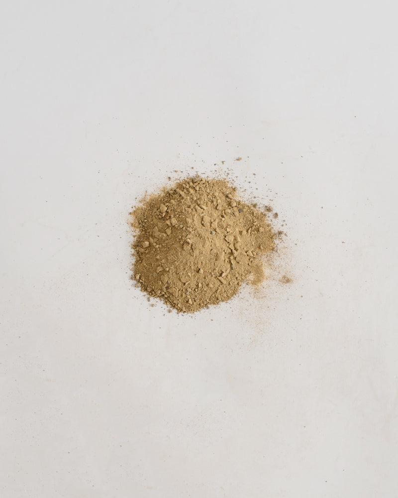 Pile of brown sand on a light gray background