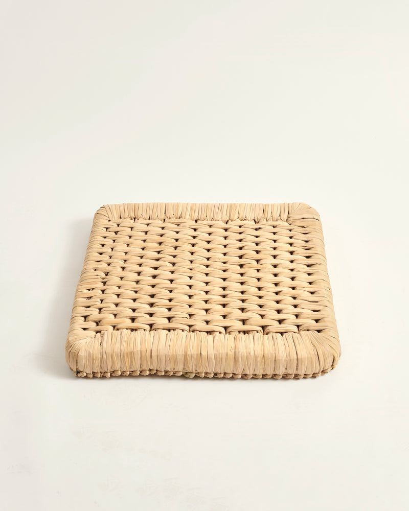 Woven beige square coaster on a white background