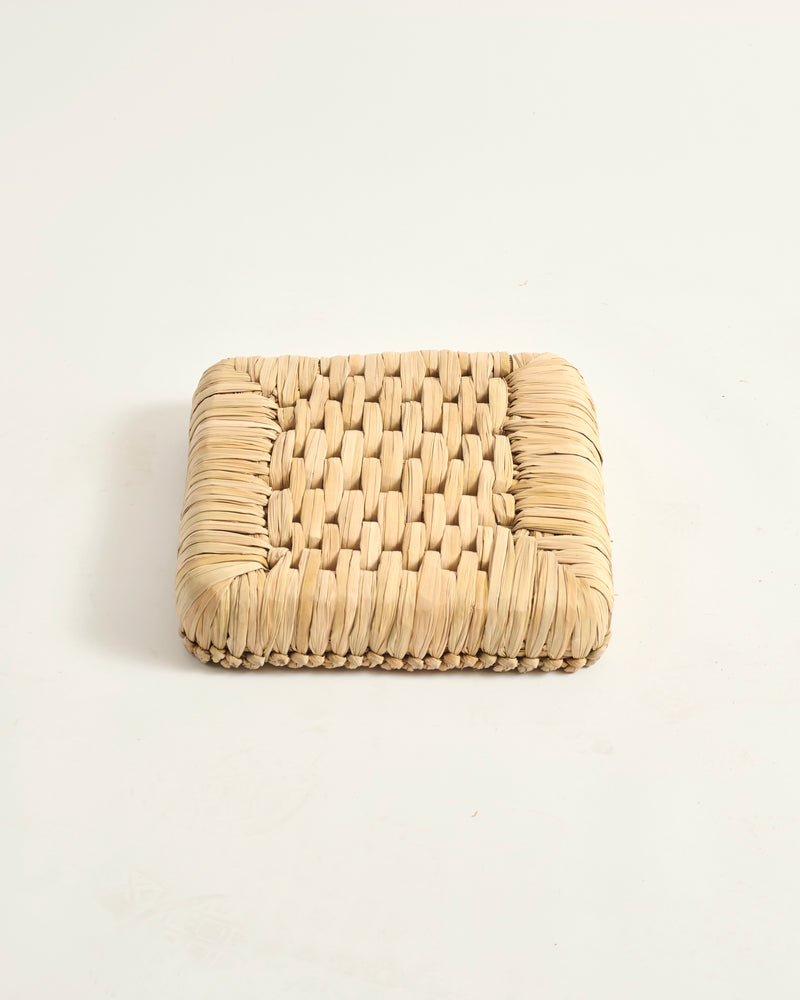 Woven beige square coaster on a white background